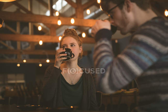 Casal tomando café no balcão no café — Fotografia de Stock