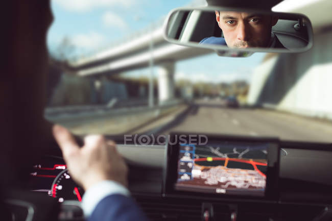 Spiegelbild eines Geschäftsmannes am Steuer eines Autos — Stockfoto