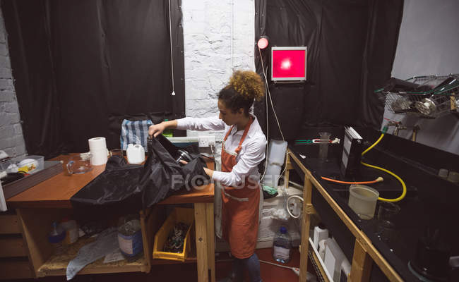 Молодая женщина-фотограф работает в фотостудии — стоковое фото