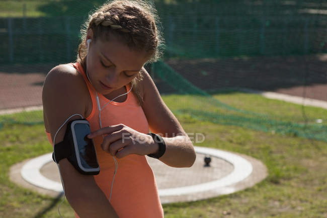 Jovem atleta feminina usando braçadeira — Fotografia de Stock