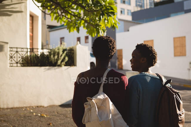 Rear view of twins siblings standing with backpack — Stock Photo