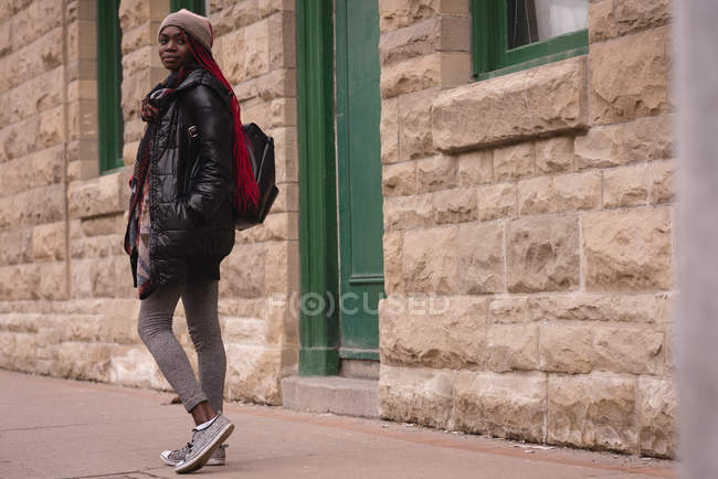 Woman walking on a sidewalk in city street — Stock Photo