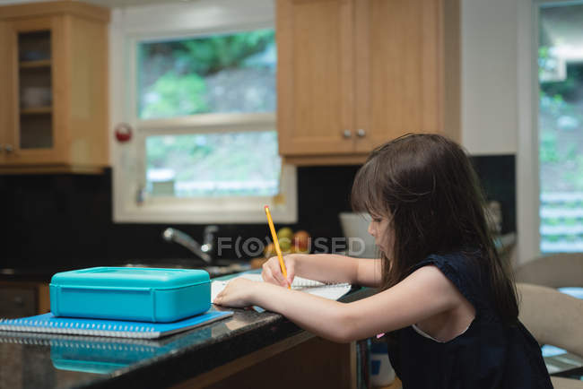 Entzückendes Mädchen, das zu Hause Hausaufgaben macht — Stockfoto