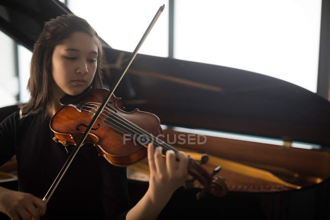 Adorable schoolgirl playing violin in music school — Stock Photo