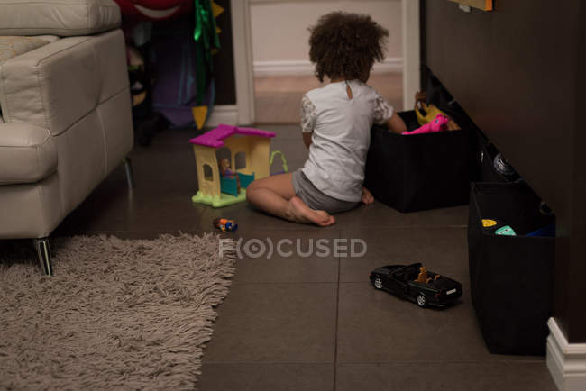 Chica jugando con juguete en la sala de estar en casa - foto de stock