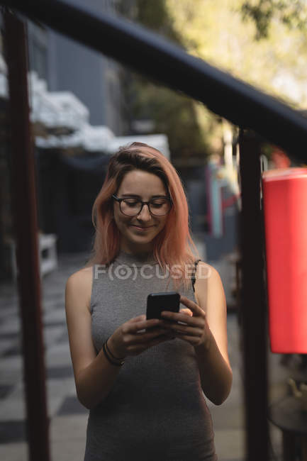 Молодая женщина использует мобильный телефон в кафе — стоковое фото