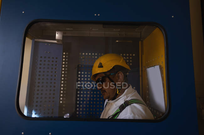 Ingénieur debout à l'intérieur ascenseur de service d'une éolienne — Photo de stock
