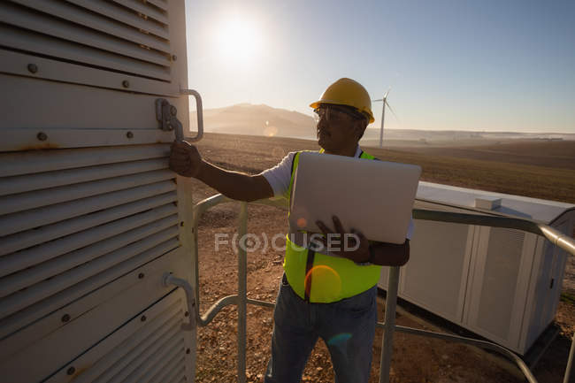 Ingeniero abriendo la puerta de entrada del molino de viento en un parque eólico - foto de stock