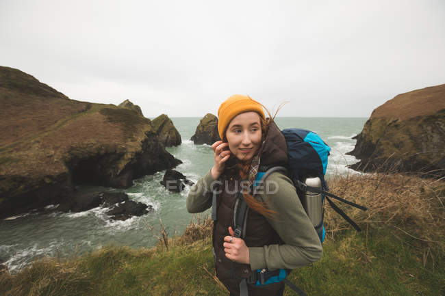 Hermoso excursionista despreocupado de pie cerca de la costa del mar - foto de stock