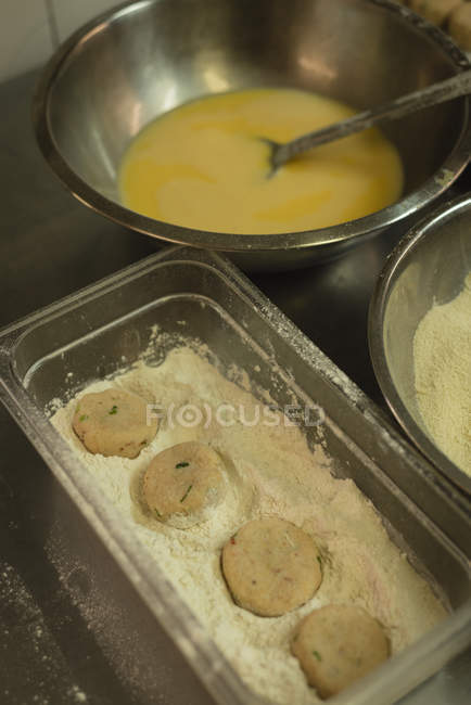Close-up of dough balls in flour at kitchen — Stock Photo