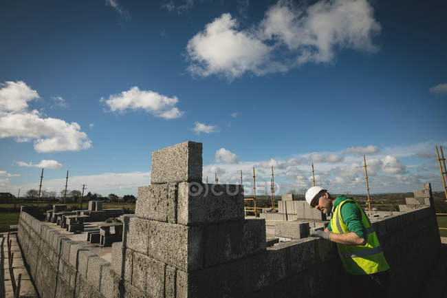 Concentrated engineer examining the wall at construction site — Stock Photo