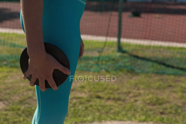 Mid section of female athlete practicing discus throw — Stock Photo