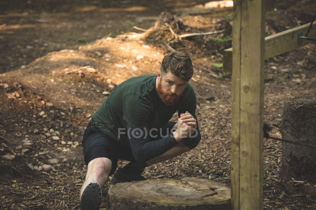 Hombre en forma haciendo ejercicio en el campamento de entrenamiento en un día soleado - foto de stock