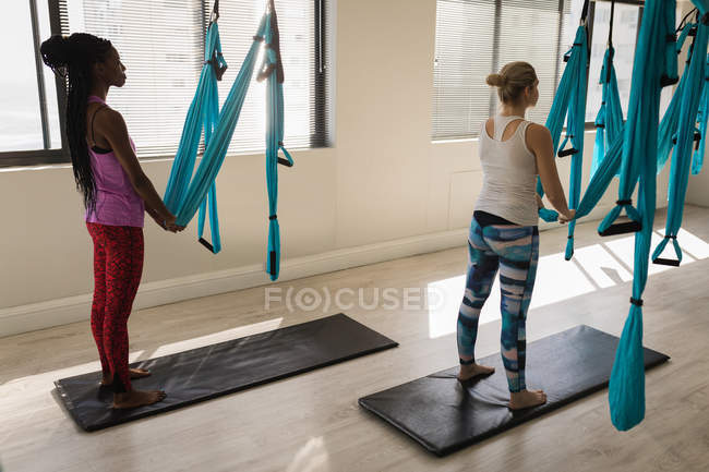 Two women performing yoga exercise in fitness studio — Stock Photo