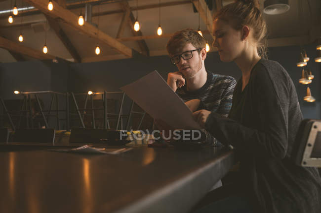 Young couple checking the menu card at restaurant — Stock Photo
