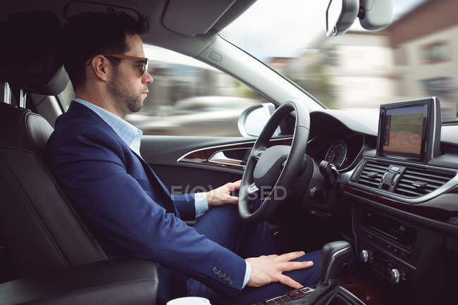 Uomo d'affari intelligente alla guida di un'auto — Foto stock