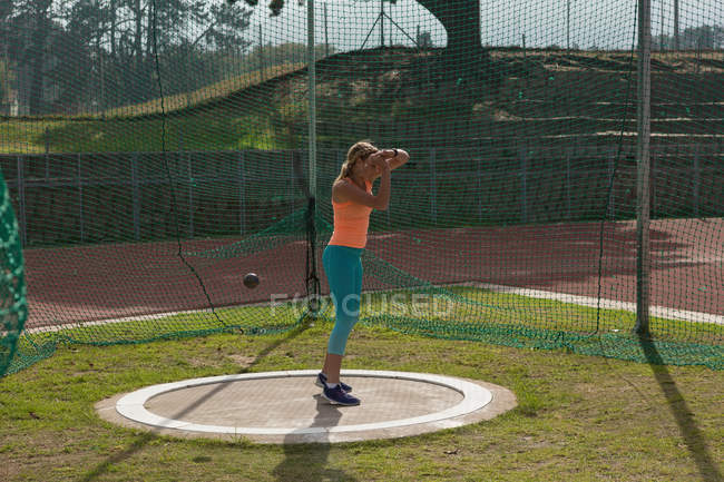 Sportlerin übt Kugelstoßen an Sportstätte — Stockfoto