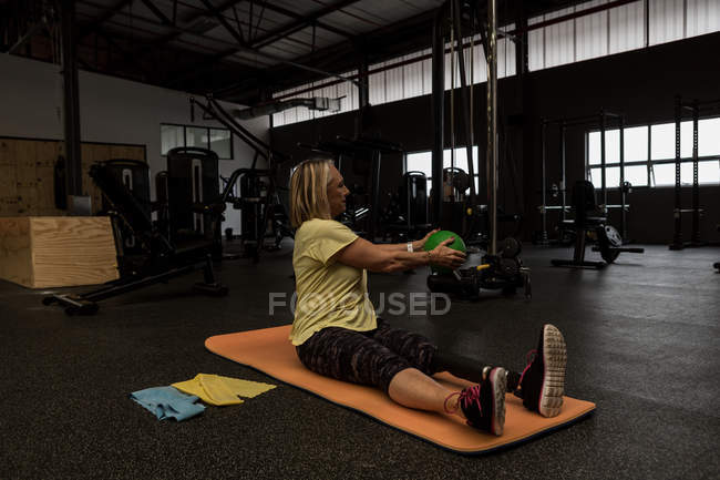Behinderte Frau trainiert mit Ball im Fitnessstudio — Stockfoto