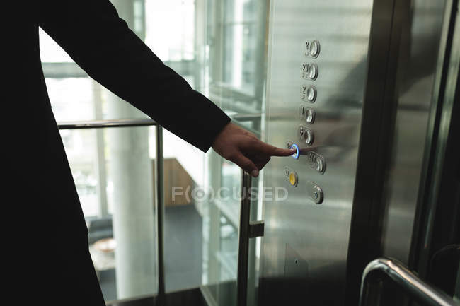 Businessperson pressing a button in the office elevator — Stock Photo