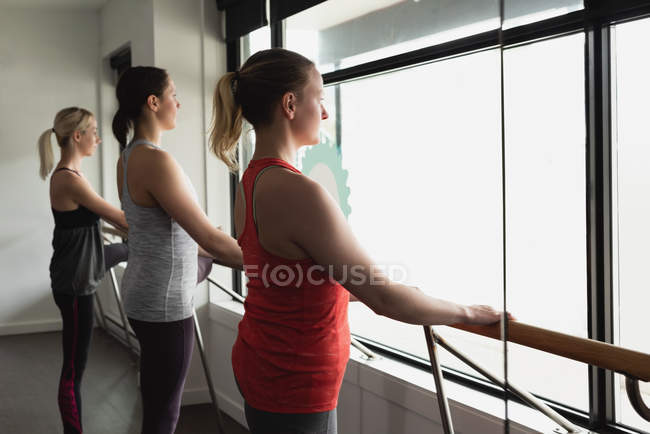 Group of women standing holding the barre at the gym — Stock Photo