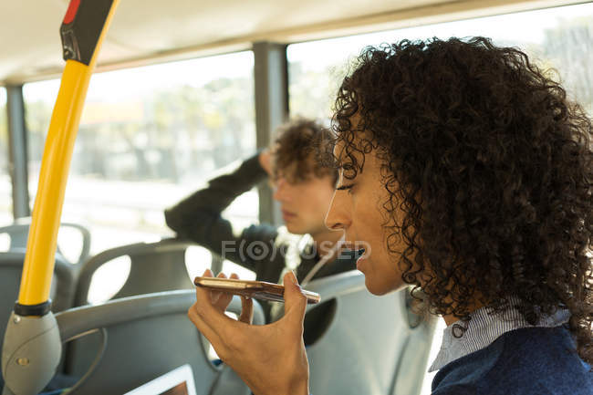 Femme parlant sur un téléphone portable pendant qu'elle voyageait dans le bus — Photo de stock