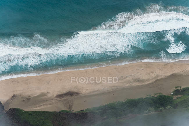 Aérea de las olas del mar que se estrellan en la costa - foto de stock