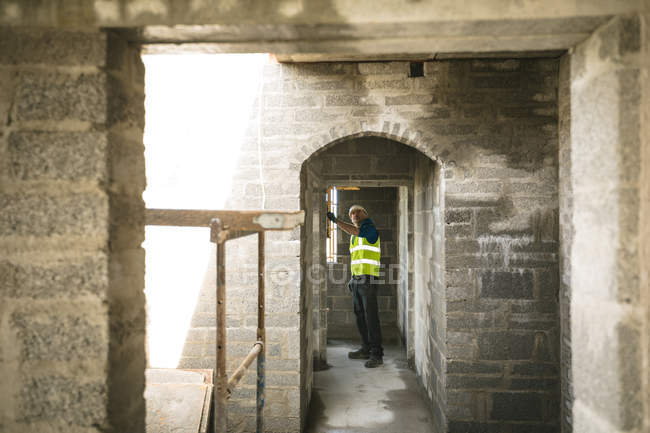 Инженер проводит проверку уровня в дверном проеме на строительной площадке — стоковое фото
