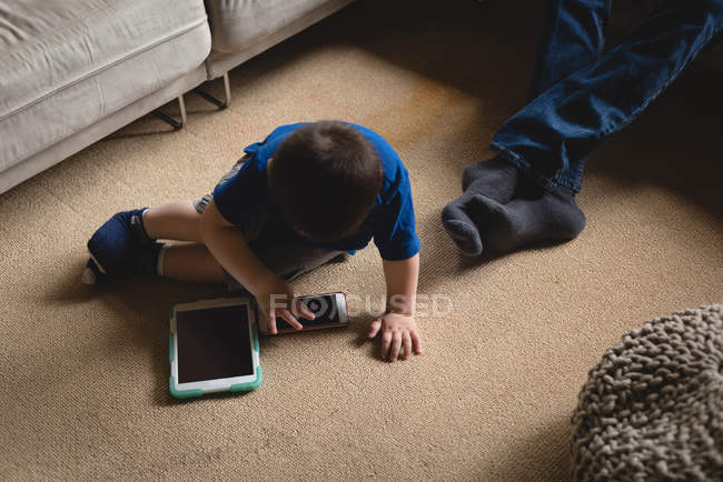 Хлопчик, використовуючи цифровий планшетний у вітальні на дому — стокове фото