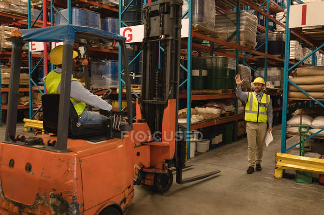 Работники мужского пола взаимодействуют друг с другом на складе — стоковое фото