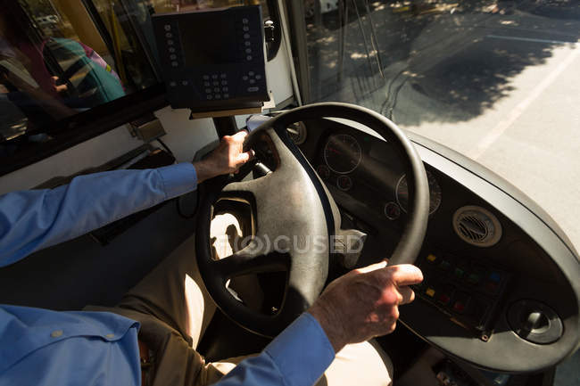 Mid section of driver driving bus — Stock Photo