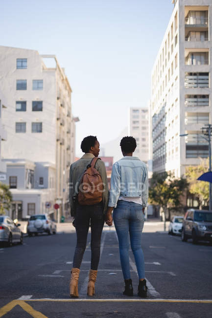 Вид ззаду близнюків братів і сестер, що стоять на міській вулиці — стокове фото