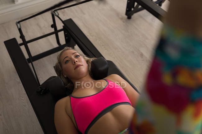 Woman exercising on stretching machine in fitness studio — Stock Photo