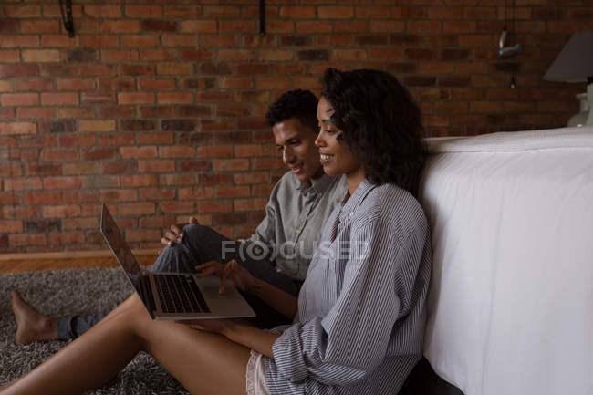 Пара використовує ноутбук у спальні вдома — стокове фото