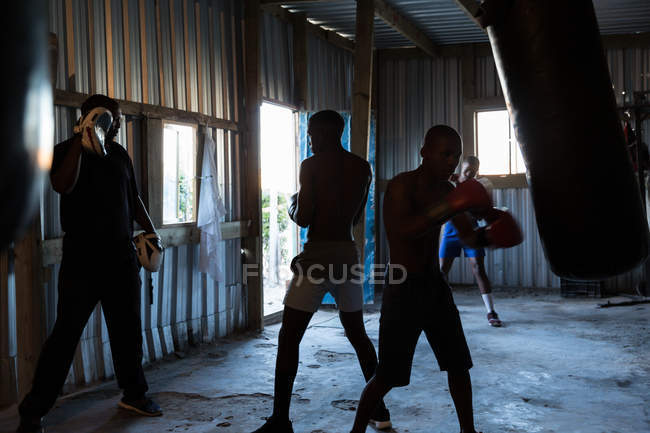 Treinador masculino treinando seus alunos em estúdio de fitness — Fotografia de Stock