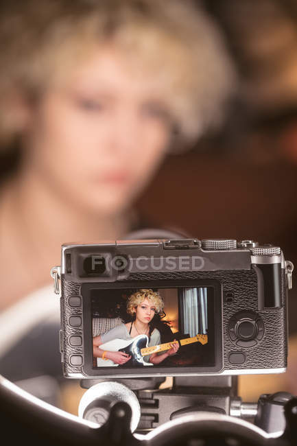Recording of female blogger playing guitar in camera at home — Stock Photo