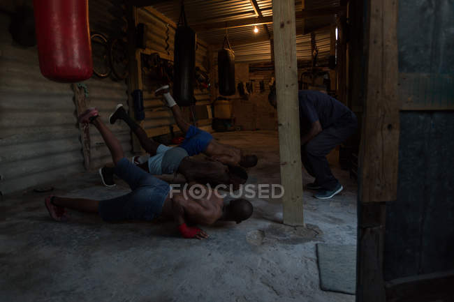 Trainer training young male boxers in fitness studio — Stock Photo