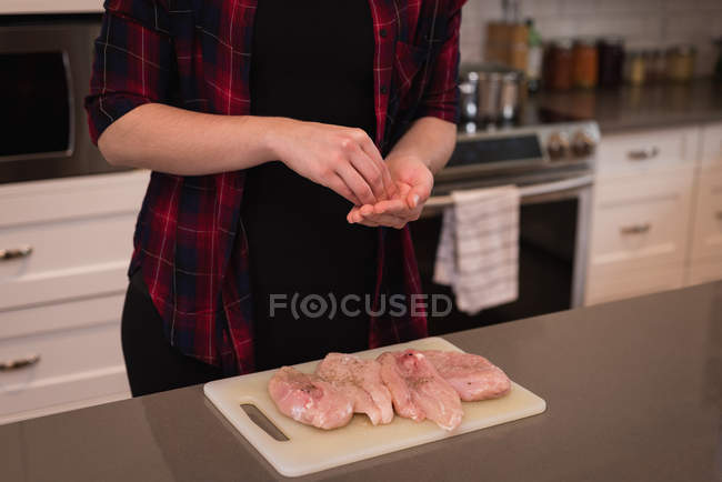 Woman preparing meat in kitchen at home — Stock Photo