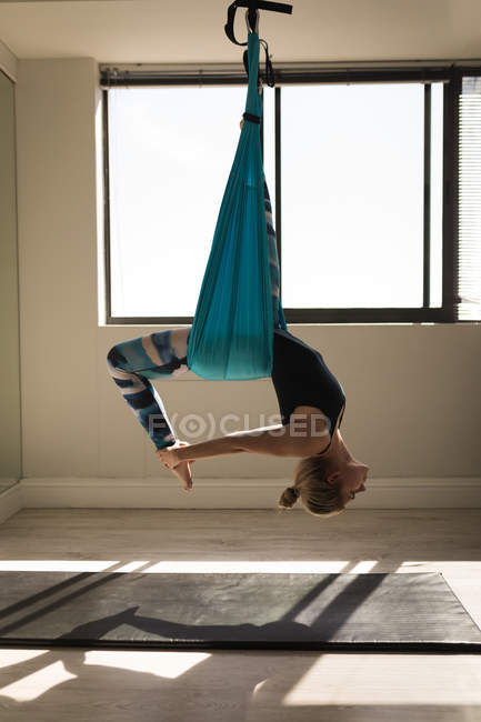 Femme faisant de l'exercice sur un hamac balançoire au studio de fitness — Photo de stock