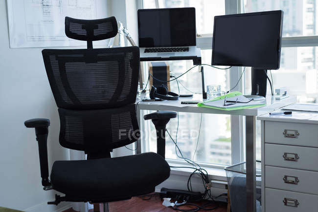 Порожнє крісло з ноутбуком та персональним комп'ютером вдома — стокове фото