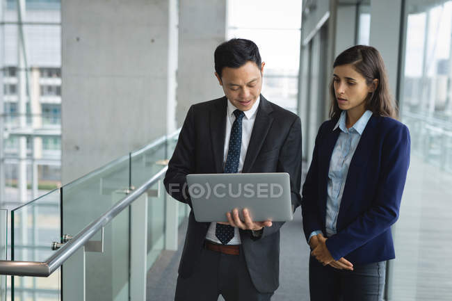 Empresário e mulher de negócios discutindo sobre o laptop no escritório — Fotografia de Stock