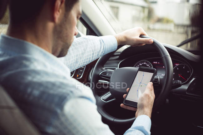 Empresário usando telefone celular em um carro moderno — Fotografia de Stock