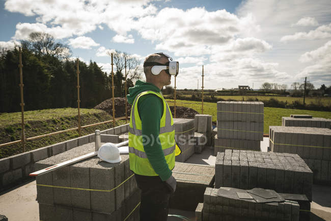 Инженер, использующий гарнитуру VR на строительной площадке в солнечный день — стоковое фото