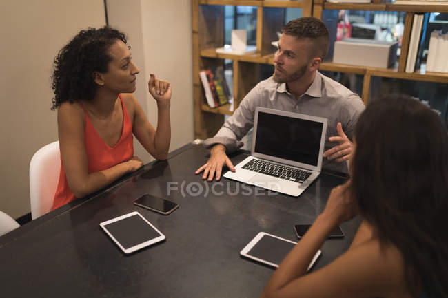 Бизнес-руководители обсуждают за ноутбуком в офисе — стоковое фото