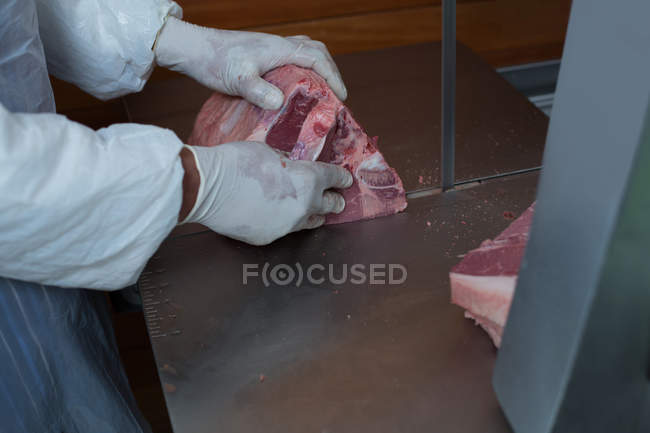 Средняя часть мясника держит мясо в мясной лавке — стоковое фото