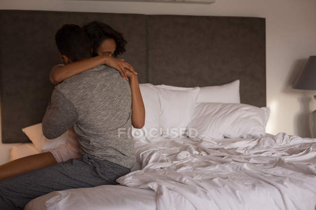 Пара обнимает друг друга в спальне дома — стоковое фото
