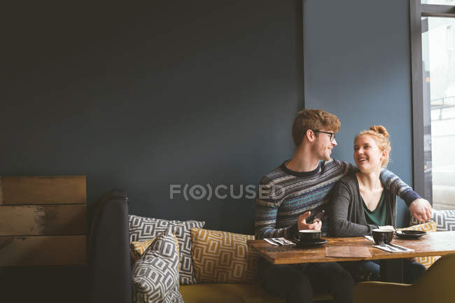 Романтическая пара разговаривает друг с другом в кафе — стоковое фото
