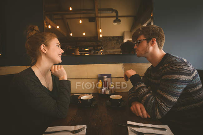 Молодая пара разговаривает друг с другом в ресторане — стоковое фото