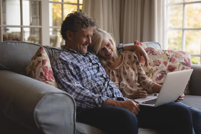 Happy senior couple doing a video call at home — Stock Photo