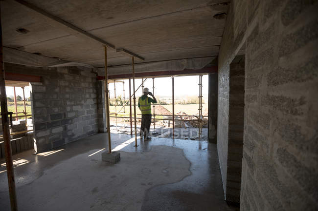 Engineer talking on the phone at construction site — Stock Photo