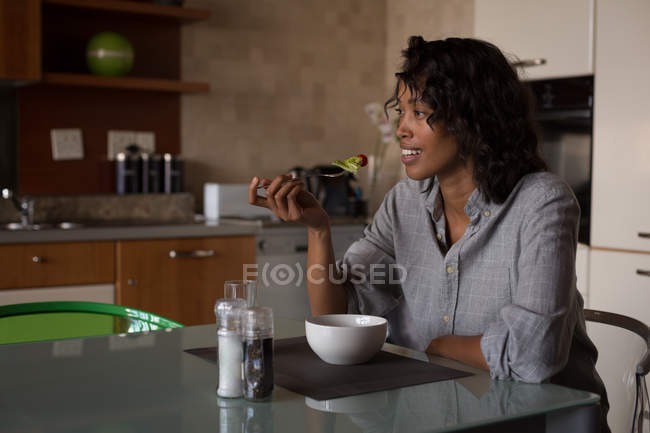 Счастливая женщина завтракает дома — стоковое фото